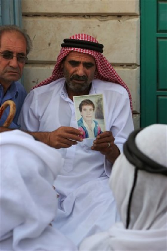 Salah Qawasmeh, father of 37-year-old Izzedine Qawasmeh, holds his son's portrait after he heard the news of his death at the family house in the village of Sair near the West Bank city of Hebron, on Sunday.